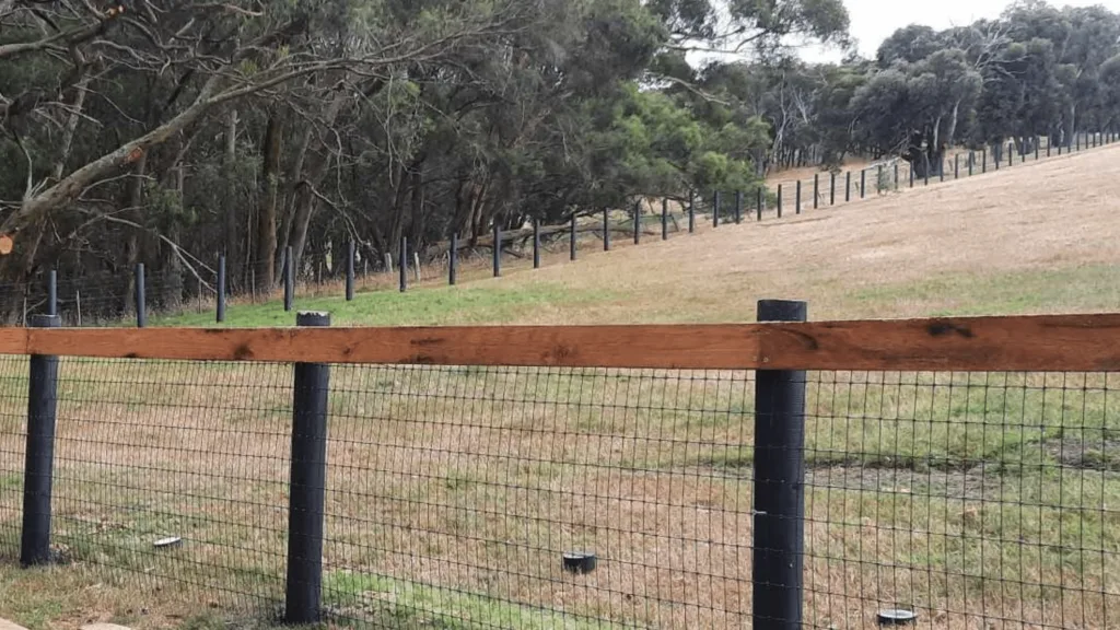 Wood and wire field fence across pasture